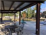 View larger image of Seating under an awning by the pool at GRAND TEXAS RV RESORT image #12
