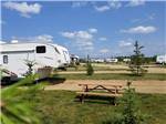 A picnic table next to an RV site at RENDEZ VOUS RV PARK & STORAGE - thumbnail