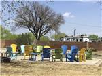 Colorful chairs around a fire pit at CONCHO PEARL RV ESTATES - thumbnail