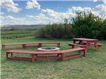 Fire ring surrounded by wooden benches at SLEEPING WOLF CAMPGROUND & RV PARK - thumbnail