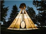 One of the teepees lit up at night at BUFFALO RIDGE CAMP RESORT - thumbnail