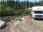 A camper parked next to the river at RANCH HOUSE LODGE & RV CAMPING - thumbnail