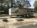 A travel trailer parked in a RV site at OKEFENOKEE PASTIMES CABINS & CAMPGROUND - thumbnail