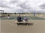 View larger image of A couple watching people play pickleball at RETAMA VILLAGE image #3