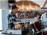 View larger image of A man in a hat playing drums at BLUEBONNET RV RESORT image #3