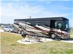 View larger image of A big rig motorhome at one of the pull-thru sites at WHISTLE STOP RV RESORT image #10