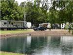 Travel trailers parked around the pond at Stonebridge RV Park & Resort - thumbnail