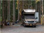 A motorhome on a RV site surrounded by trees at SHELTER COVE RESORT AND MARINA - thumbnail