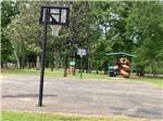 View larger image of Basketball court with playground in distance at HIDDEN SPRINGS RV RESORT image #10