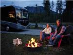 View larger image of A couple roasting marshmallows at campsite at WEST GLACIER RV PARK  CABINS image #2