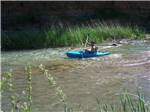 View larger image of A person kayaking down the river at RAIN SPIRIT RV RESORT image #10