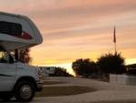 RV with view of flag at sunset at Al's Hideaway Cabins & RV Park - thumbnail