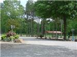 View larger image of Gravel circle drive with trees and pavilion at RED RIVER RV PARK image #5