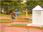 Girl playing at miniature golf course at THOUSAND TRAILS HARBOR VIEW - thumbnail
