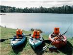 Three kayaks on the grass next to the river at CREEKFIRE RESORT - thumbnail