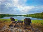Two adirondack chairs and a table next to the lake at CREEKFIRE RESORT - thumbnail