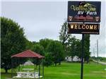 View larger image of Sign at park entrance with covered seating area at VALLEY INN RV PARK image #1