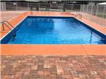 Fenced pool with brick exterior at The Oaks at Zephyrhills - thumbnail