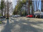 RVs parked on gravel lots under trees - thumbnail