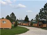 View larger image of Cabins with picnic benches and a swing with a fire pit at CUSTER CROSSING CAMPGROUND image #8