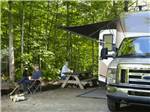 View larger image of A couple enjoying coffee by their RV at HOLLY ACRES CAMPGROUND image #8