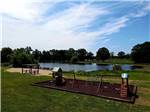 View of playground with water in background at CEDAR CREEK RESORT & RV PARK - thumbnail