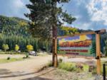 Brightly colored sign in front of a hill covered in pine trees at 4K River Ranch - thumbnail