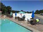 View larger image of Table and chairs by the side of a pool at TEXARKANA RV PARK image #7