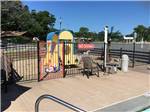 View larger image of Play area behind fence with pool in foreground at TEXARKANA RV PARK image #8