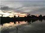 A placid lake at sunset at ST JOHNS RV RESORT - thumbnail