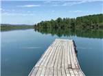 A wooden dock extends into a placid lake at CHEWING BLACK BONES CAMPGROUND - thumbnail