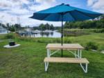 Picic table and firepit at grassy Rv site by the water - thumbnail