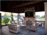 Chairs and bbq pit under a pavilion at MOTORCOACH RESORT LAKE ERIE SHORES - thumbnail