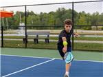A young man playing tennis at MOTORCOACH RESORT LAKE ERIE SHORES - thumbnail