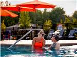 A couple lounging at the pool at MOTORCOACH RESORT LAKE ERIE SHORES - thumbnail