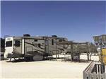 A gravel campsite with covered seating at HILLTOP RV PARK - thumbnail