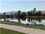 View larger image of A concrete walkway by the water at DILLON MOTORCOACH  RV PARK image #10