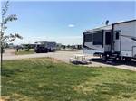Picnic table and grassy area outside parked RV at YELLOWSTONE LAKESIDE RV PARK - thumbnail