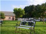 Decorative bench in the green grass at DADE CITY RESORT - thumbnail