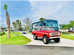A red truck and motorhome in a cement site at BAREFOOT RV RESORT - thumbnail