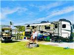 A family and dogs standing in front of their trailer at BAREFOOT RV RESORT - thumbnail