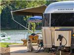 A dog standing next to a trailer at TWIN CREEKS RV RESORT - thumbnail