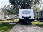 A travel trailer parked in a gravel site at SUNNY OAKS RV PARK - thumbnail