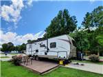 Motorhome in campsite with deck at OUTPOST RV PARK & CAMPGROUND - thumbnail