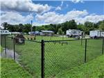 Fenced in dog park with play equipment at OUTPOST RV PARK & CAMPGROUND - thumbnail