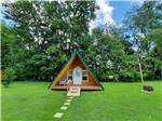 A-frame cabin with stone pavers leading to it at OUTPOST RV PARK & CAMPGROUND - thumbnail