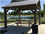 View larger image of A gazebo with a picnic table by the water at STINSON RV PARK image #7