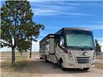 A motorhome in a gravel RV site at PINE BLUFFS RV RESORT BY RJOURNEY - thumbnail