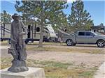 A statue next to a gravel RV site at PINE BLUFFS RV RESORT BY RJOURNEY - thumbnail