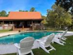 Chairs by the pool and lodge at FOREST LAKE RV PARK & EVENTS - thumbnail